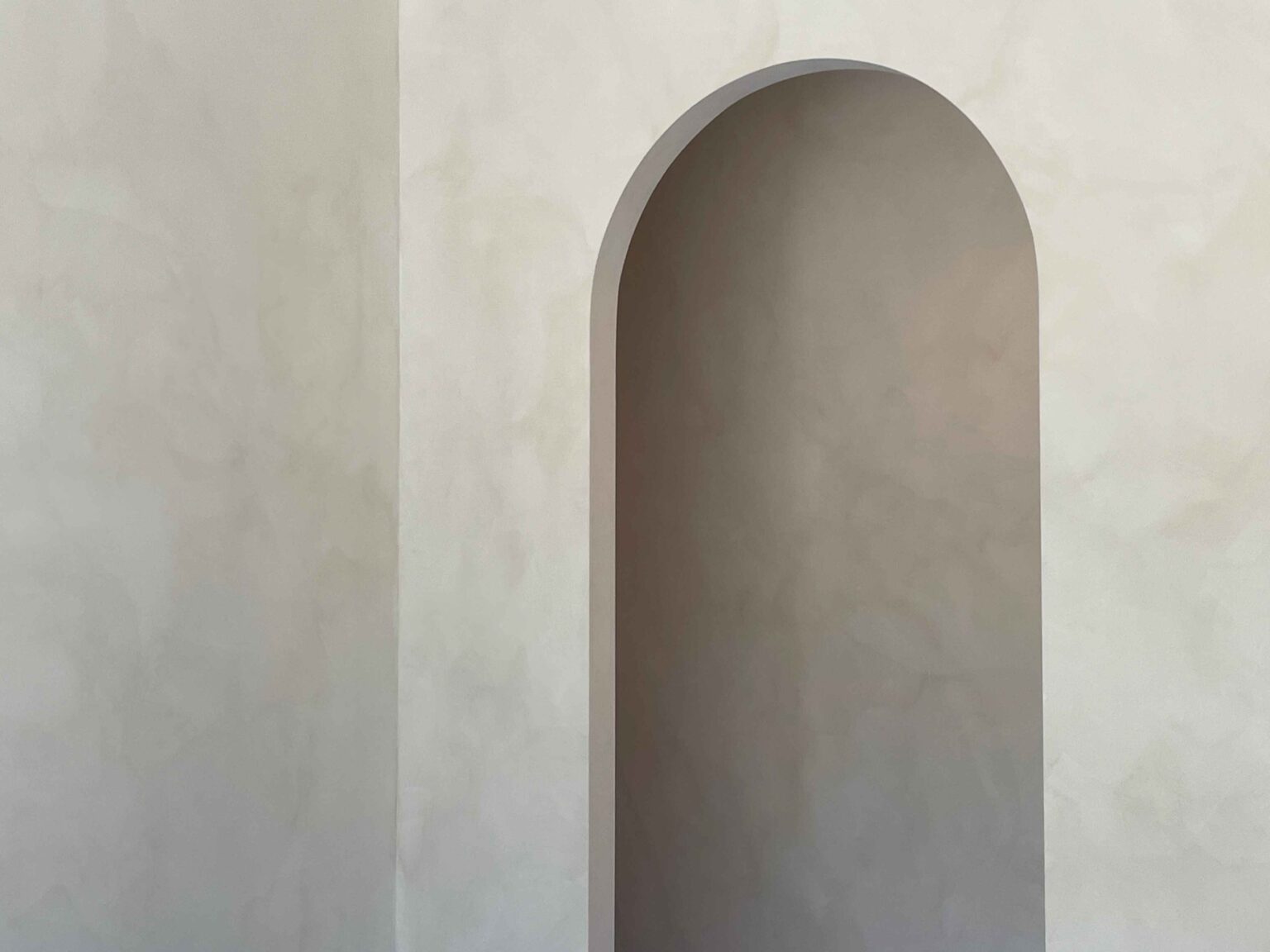 Smooth, cloudy limewash finish on an arched feature wall in an Ottawa home