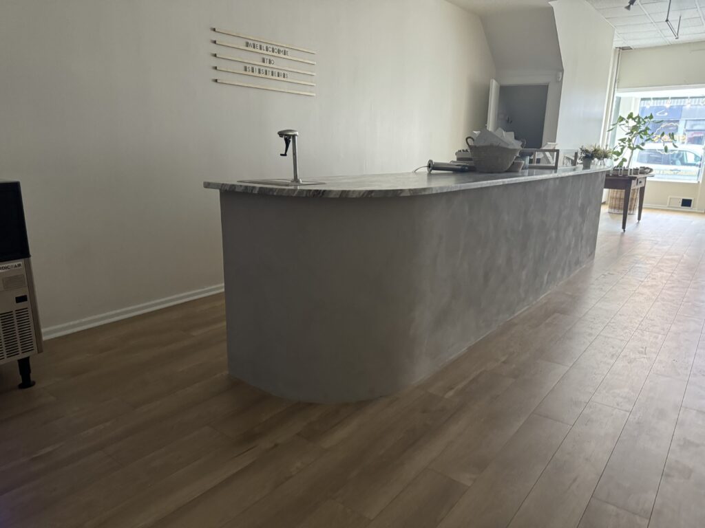 Curved concrete finish front desk in microcement, Ottawa