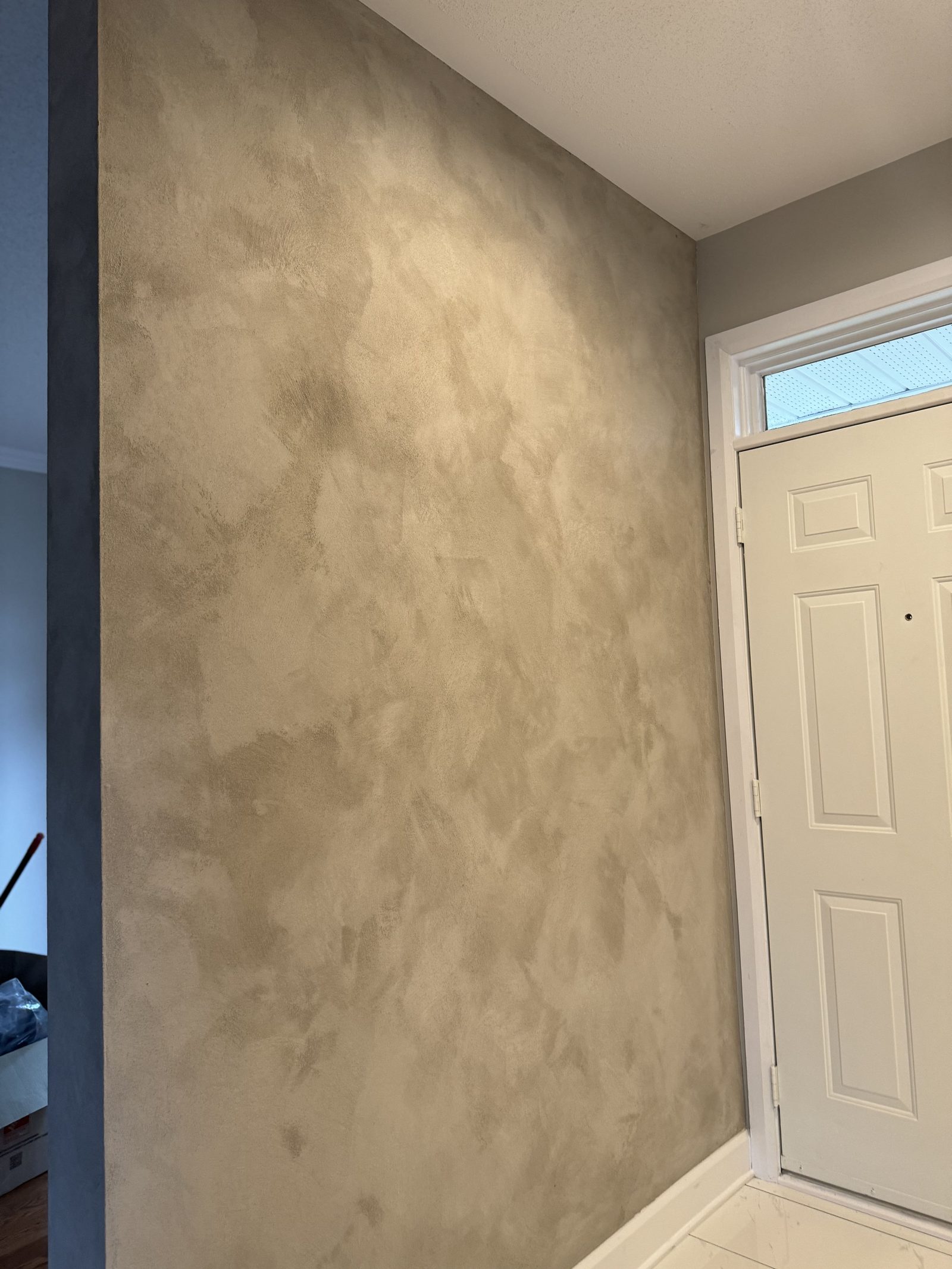 Close-up of smooth venetian plaster wall finish with subtle depth and layered sheen detail visible in side lighting