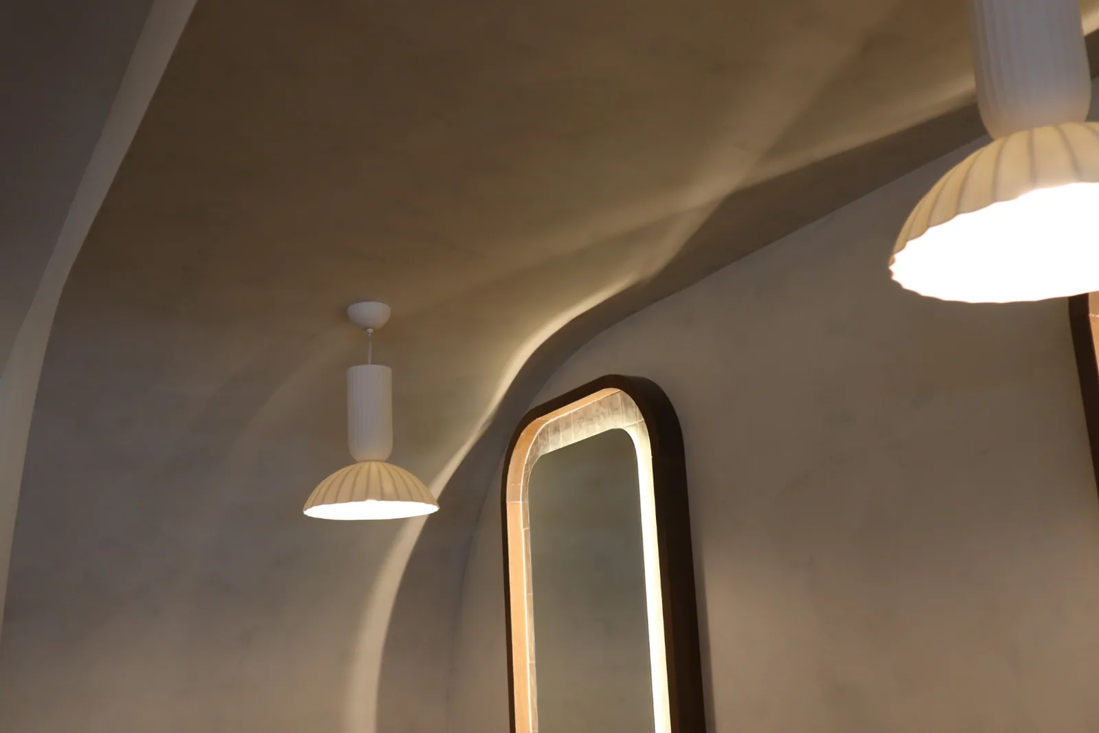 Two-tone limewash across barrel-arched ceiling coves with pendant lights and sage-green tile wainscot at Cocotte Bistro, Ottawa