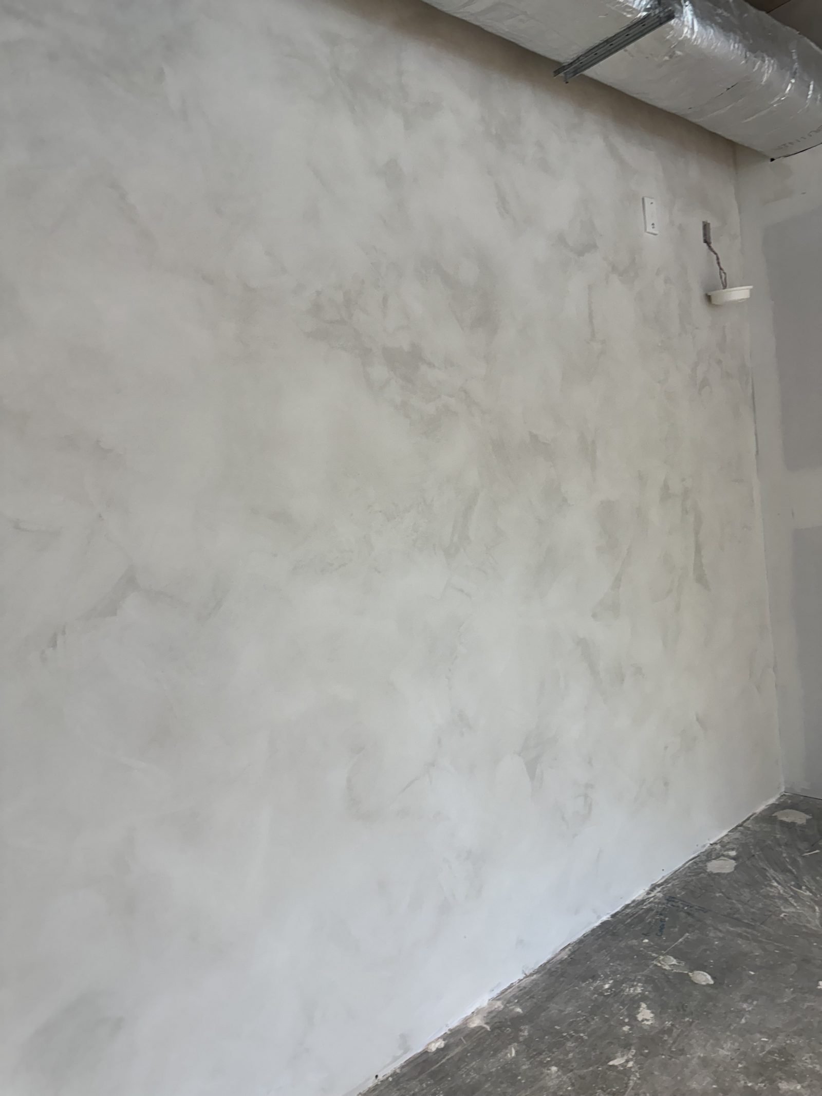 Venetian plaster finish with polished trowel marks creating subtle depth and light reflection on interior wall surface