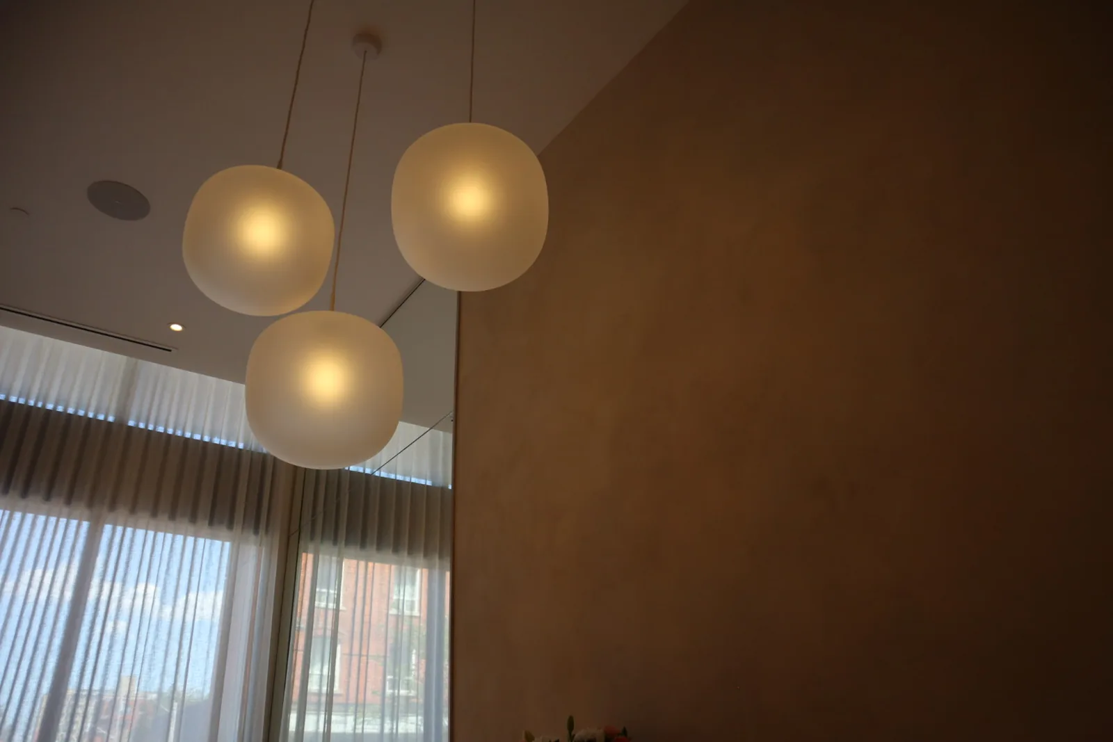 Close-up of soft cloudy two-tone limewash texture with frosted globe pendant lights, Envy Cosmetic Clinic Ottawa