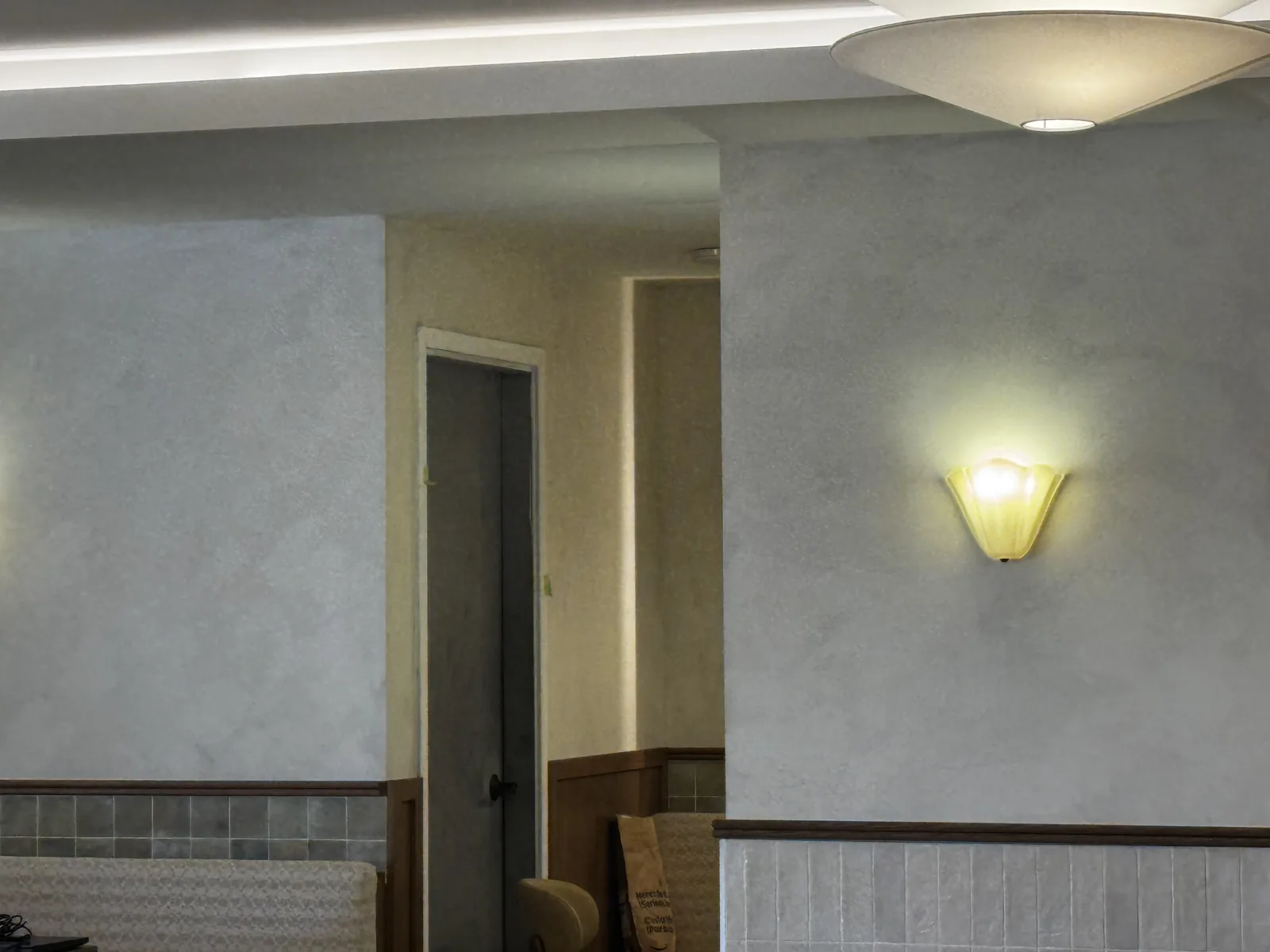 Soft two-tone limewash walls with scalloped alabaster sconces above banquette seating at Cocotte Bistro, downtown Ottawa