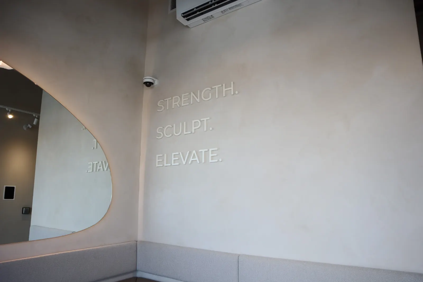 Custom limewash wall with studio lettering and mirror at Studio Eleven Pilates Ottawa